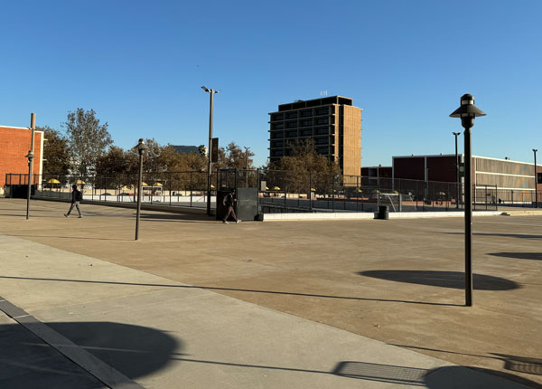 A wide angle view of a plaza with buildings and trees.