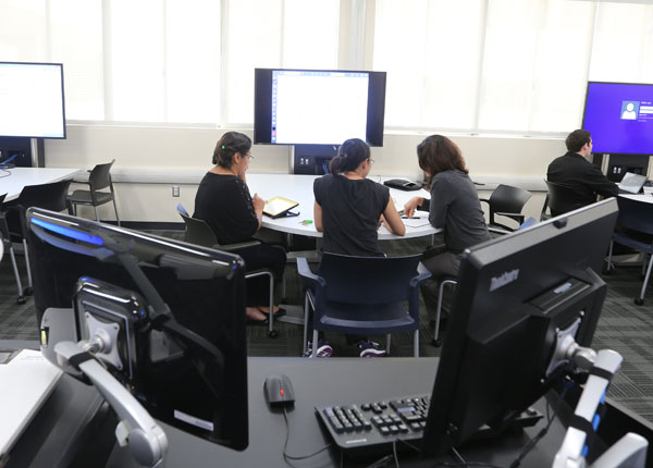 Students working as a group, using a computer station in the classroom.