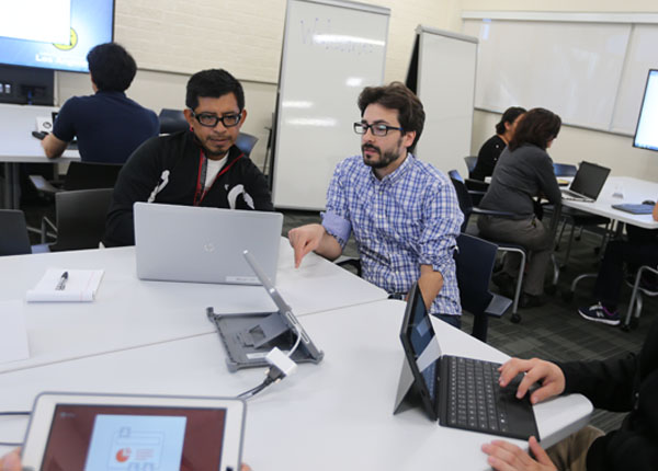Students working as a group, using a computer station in the classroom.