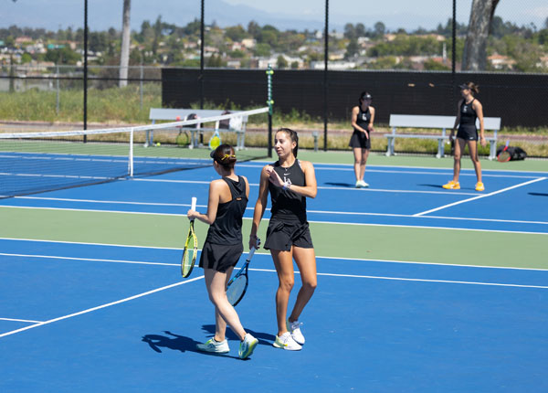 Two tennis players smiling and celebrating.
