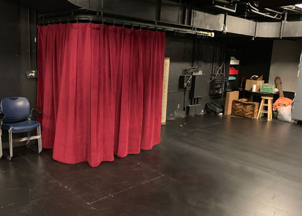 A red curtain that covers a dressing room.
