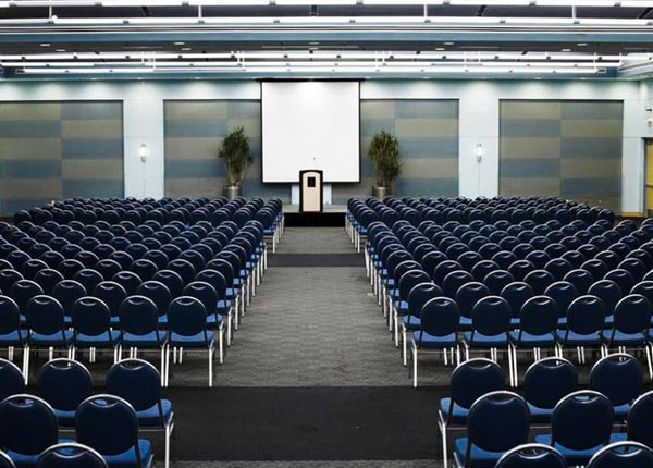 Many rows of seats in front of a podium on a stage.