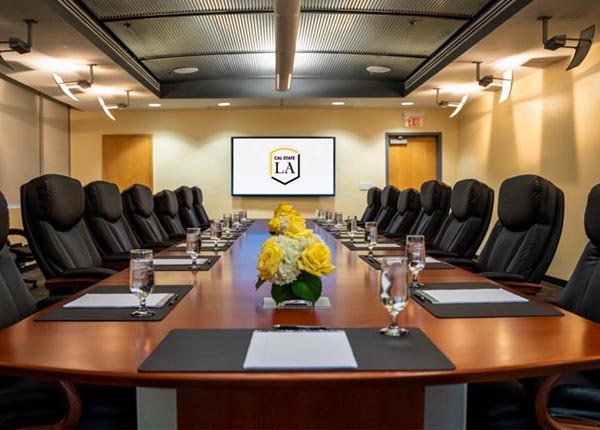 A boardroom table with many seats around it.