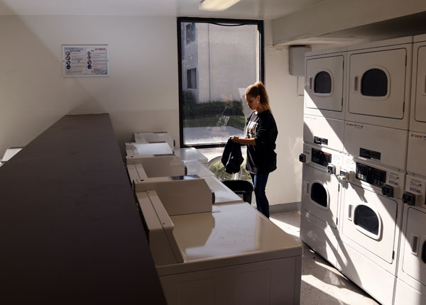 A person doing their laundry in a laundry room.