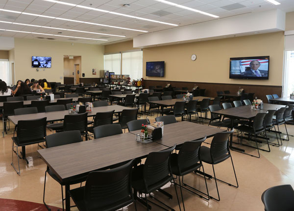 The inside of a dining hall with many tables and chairs.