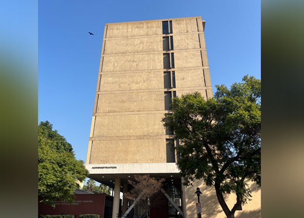 A tall tan building on a sunny day.
