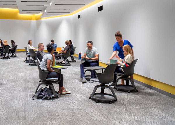 A modern lecture hall with a professor giving a lecture to a room full of students.