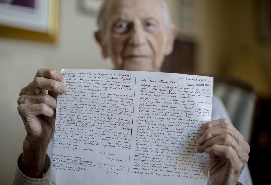 Sigmund Burke holds a handwritten letter he wrote to family in the United States in August 1945