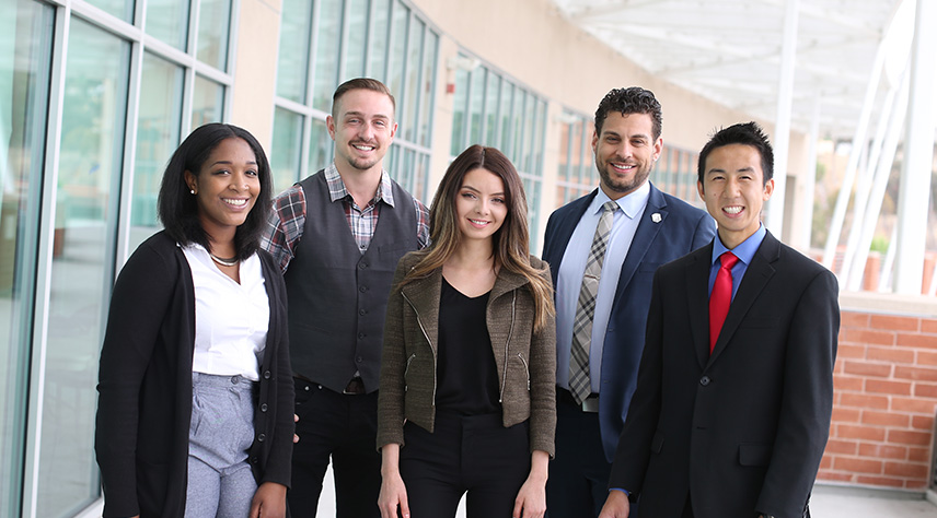 Group of give students in front of the Golden Eagle building