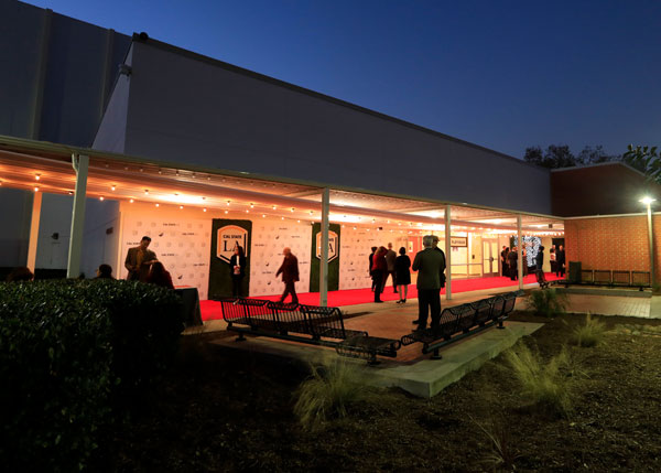 The front of a bright building at night.