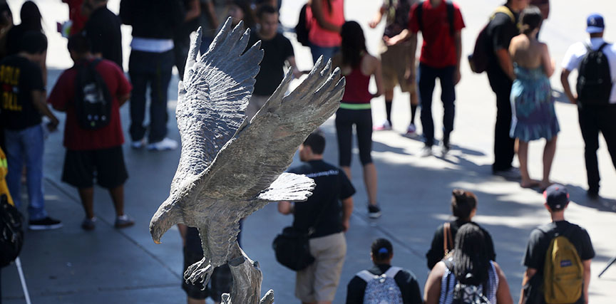 A view of the Golden Eagle statue from a top angle, students walking in the background.
