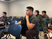 Students in a classroom facing the board