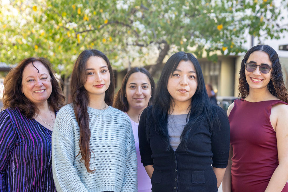 A group of students standing together on a sunny day.