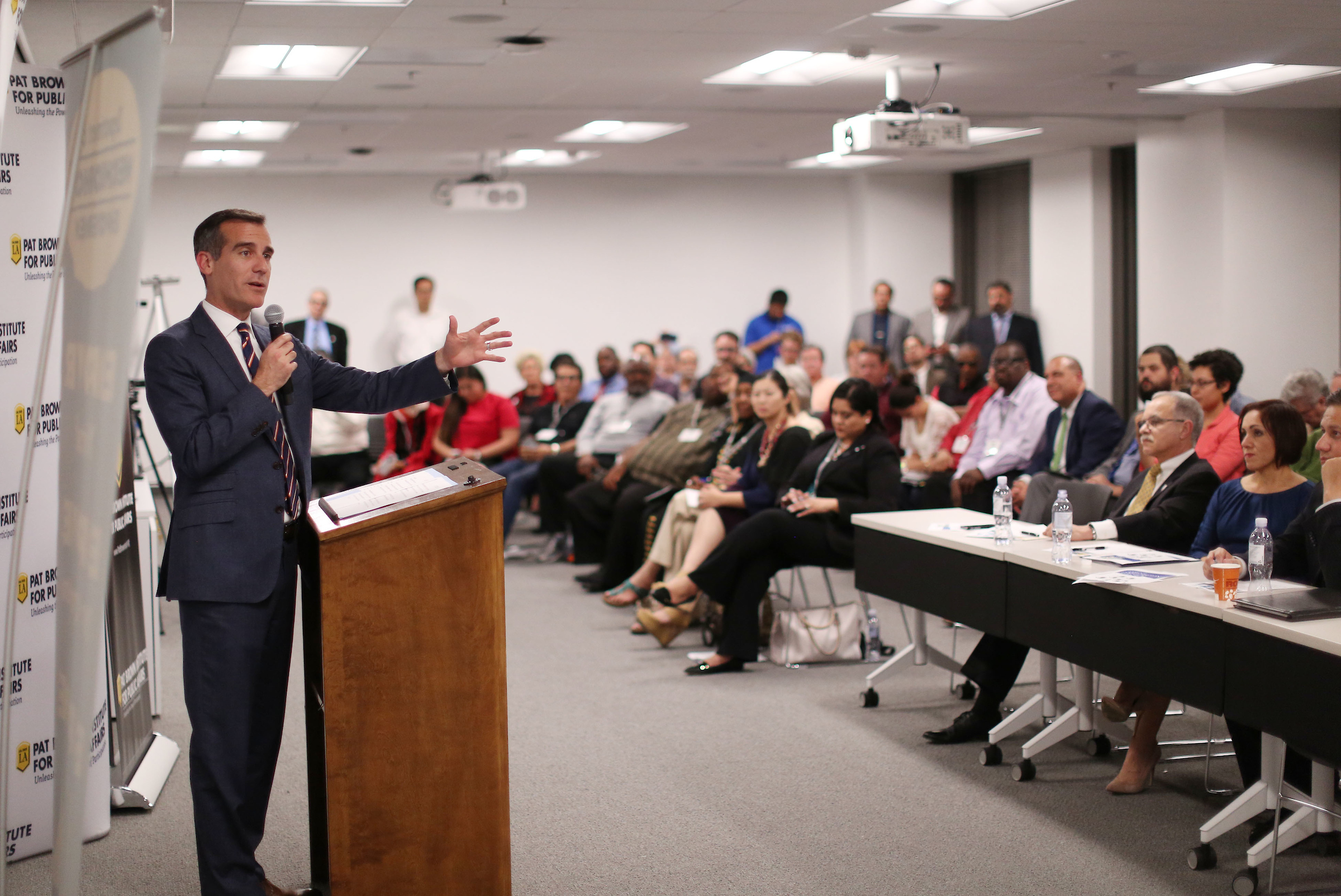 Mayor Eric Garcetti speaks with a microphone to a room full of participants of Civic University, a program organized by the Pat Brown Institute for Public Affairs at Cal State LA.