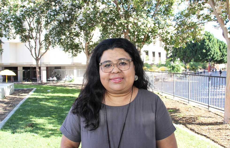 Photo of Cecilia Mejia Morales outdoors on campus with trees in the background. 
