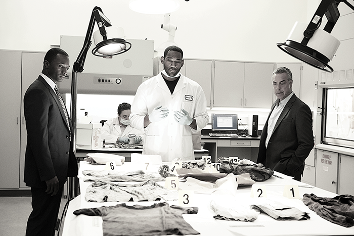 Harry Bosch (Titus Welliver), right, and his partner Jerry Edgar (Jamie Hector), left, confer with an analyst on the television series “Bosch,” which was filmed in a crime lab at Cal State L.A.