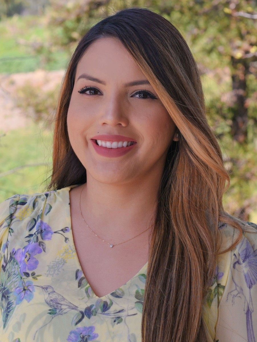 A person with long hair smiling.