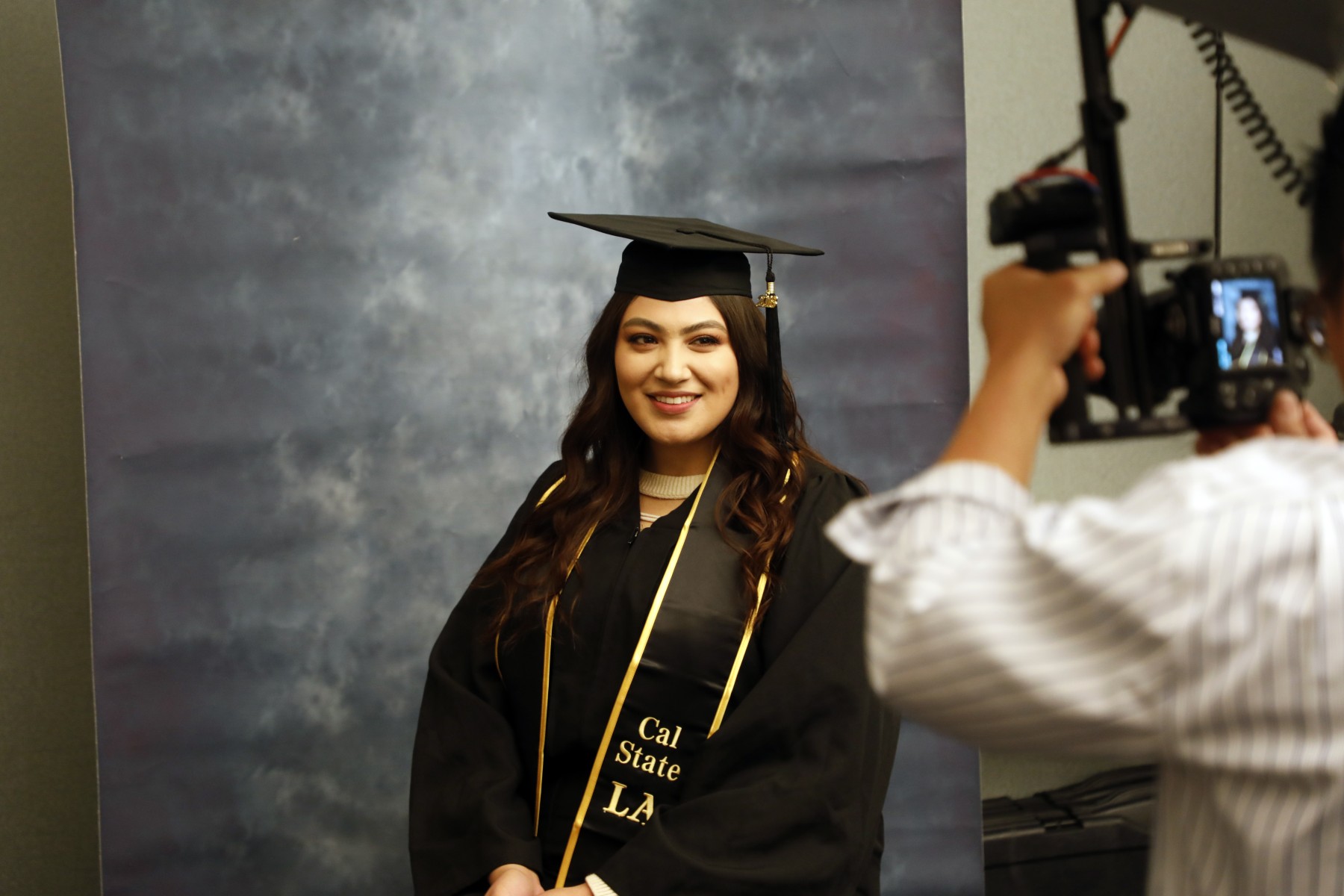 Student taking a graduation portrait.