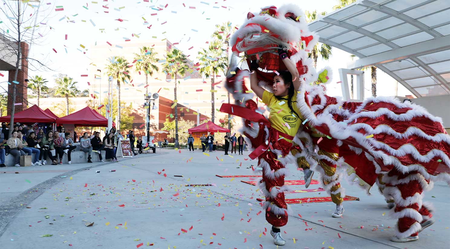 An Asian female student dancing in a lion costume