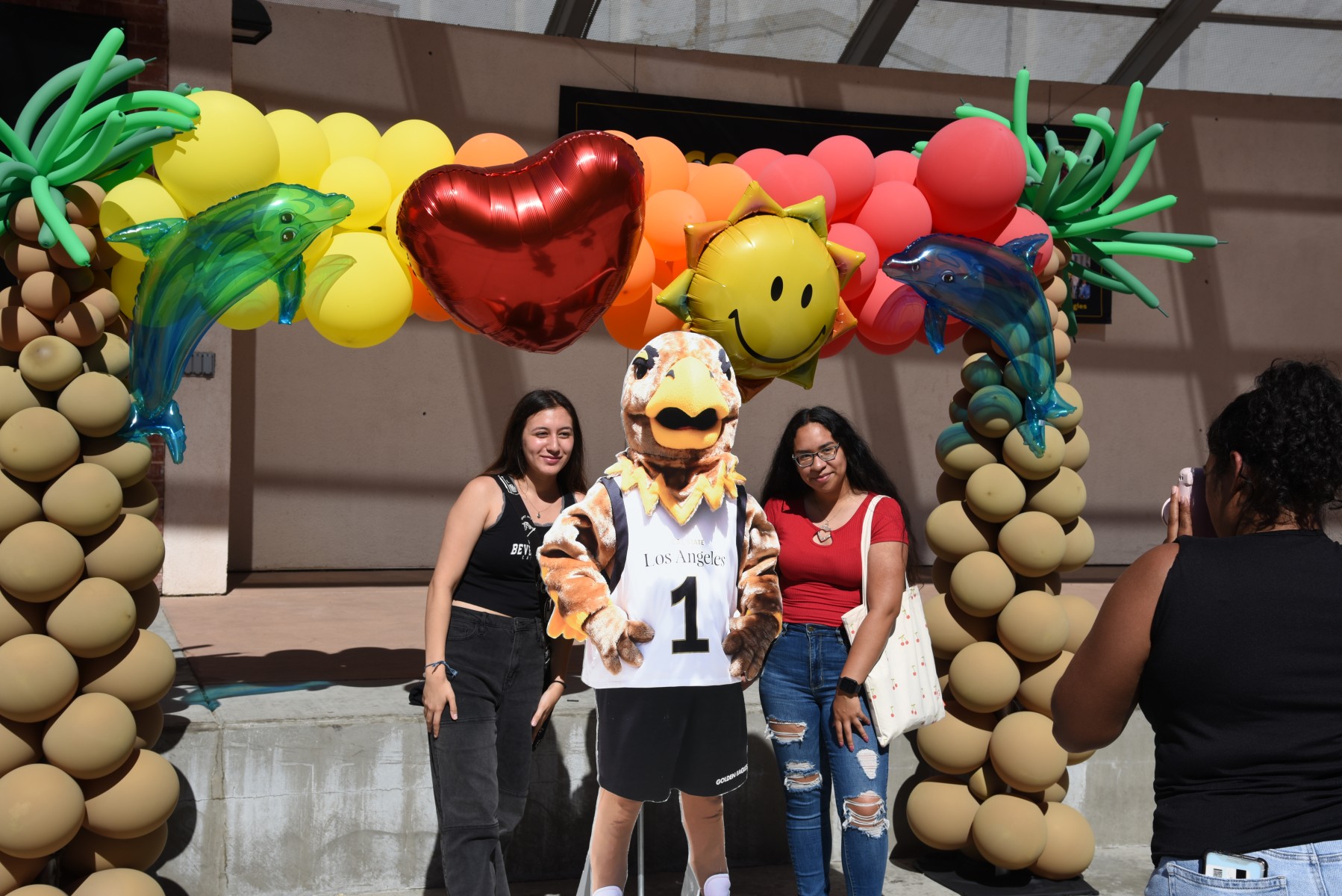 A group of people smile and post under an inflatable display