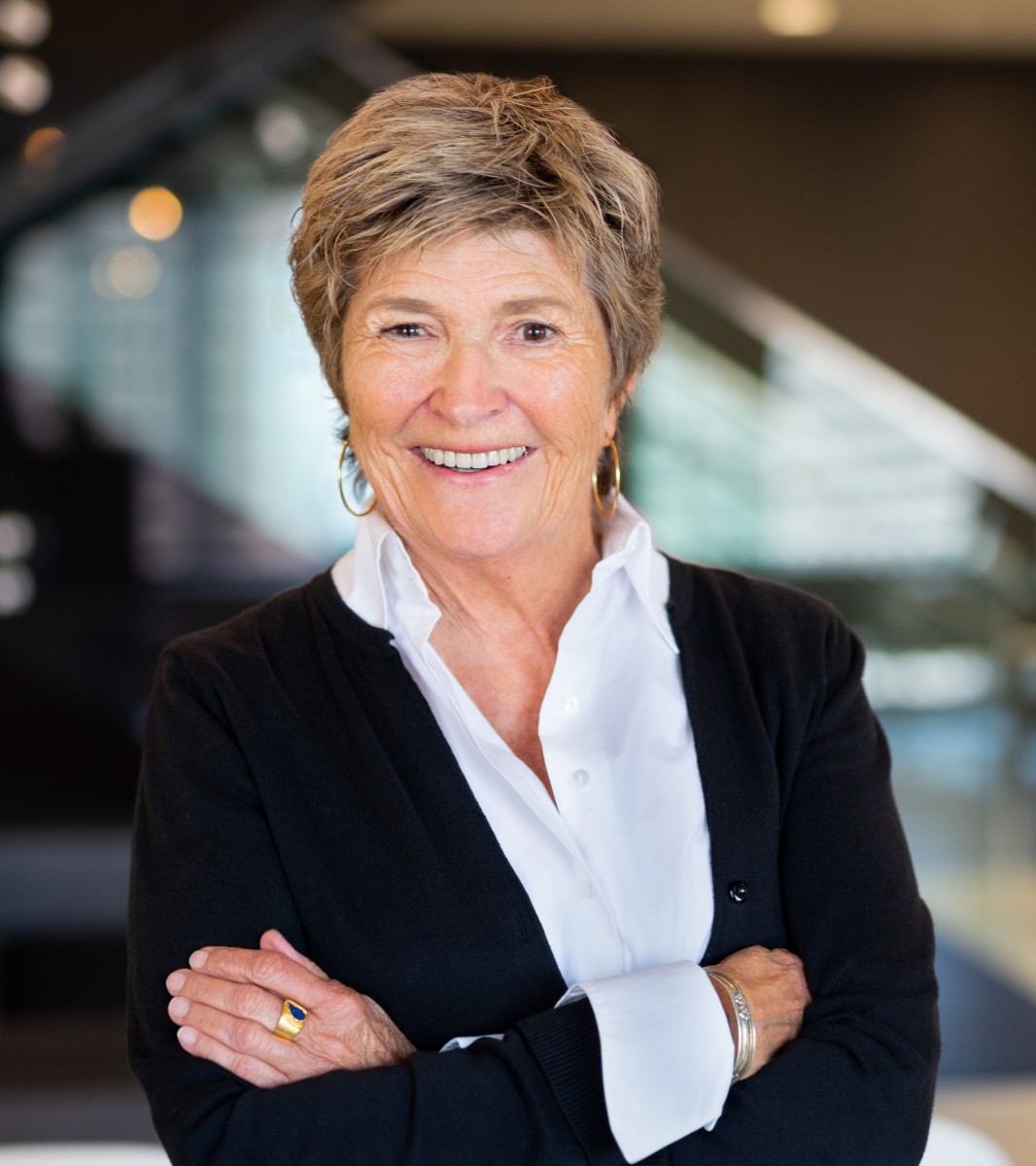 white woman with blond short hair with black sweater and white collared shirt