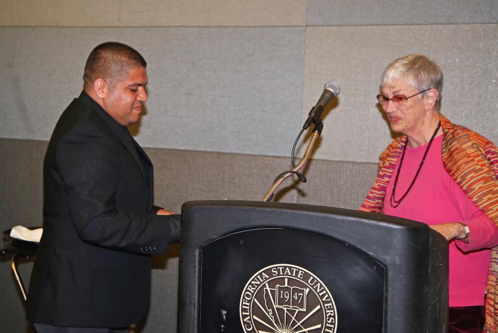 Janet Fisher-Hoult welcoming Jose Perez, male student wearing suit