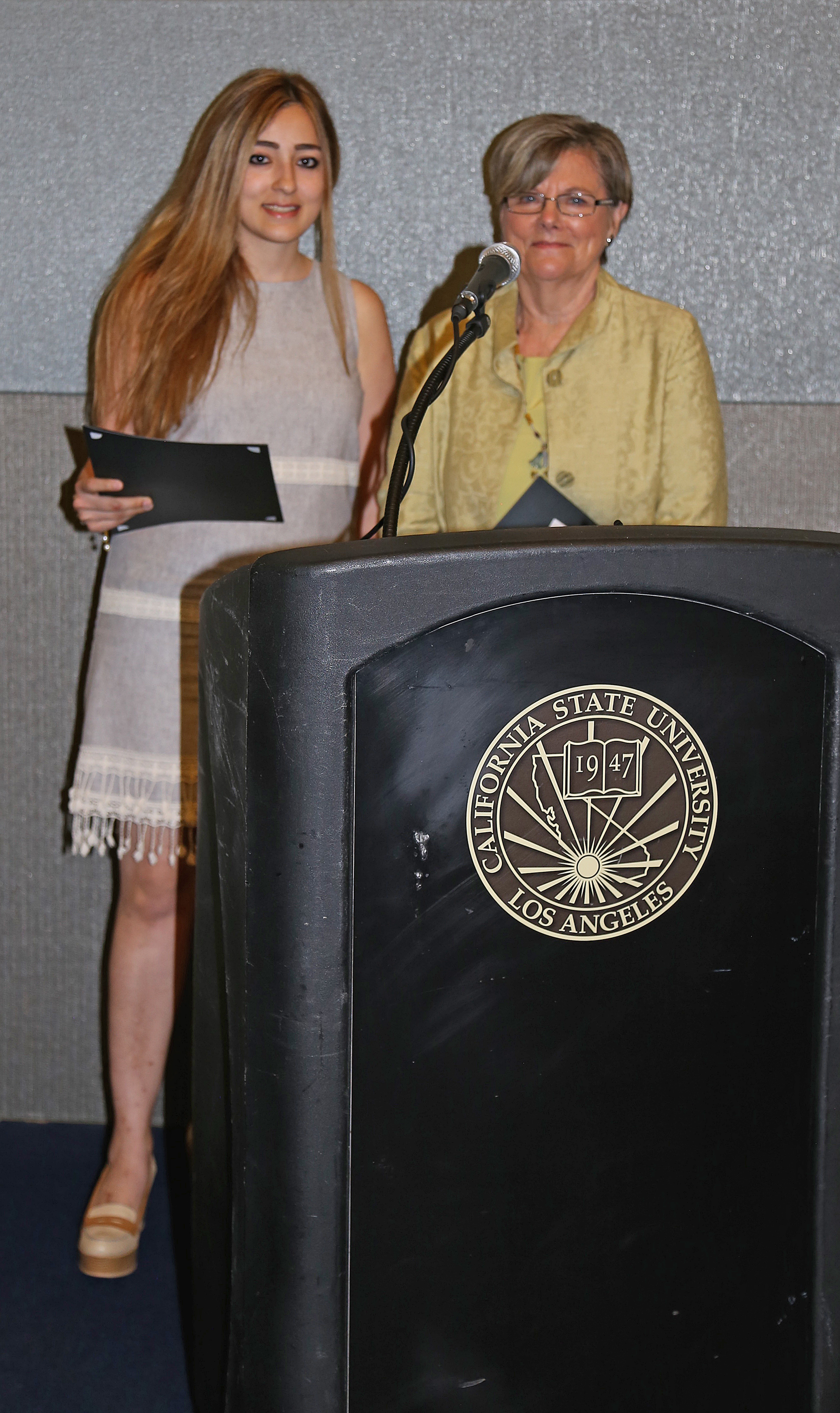 student and professor at podium at fall 2017 luncheon