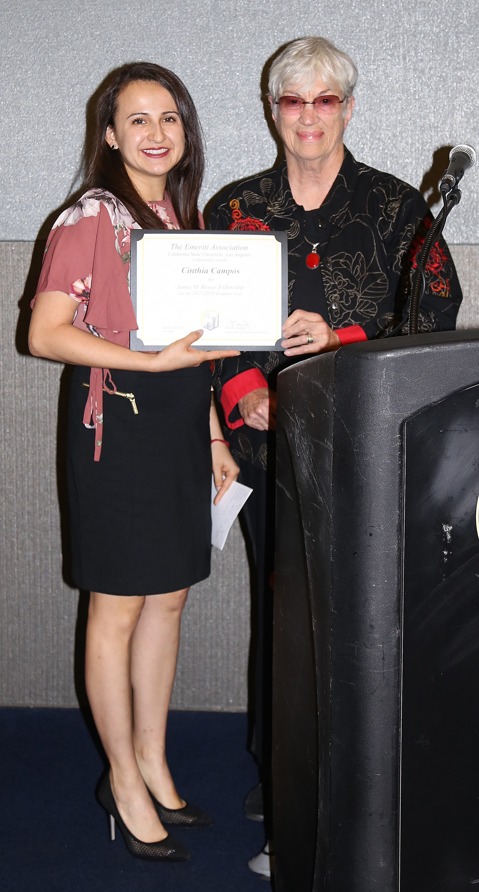 Cinthia Campos and professor at podium at fall 2017 luncheon