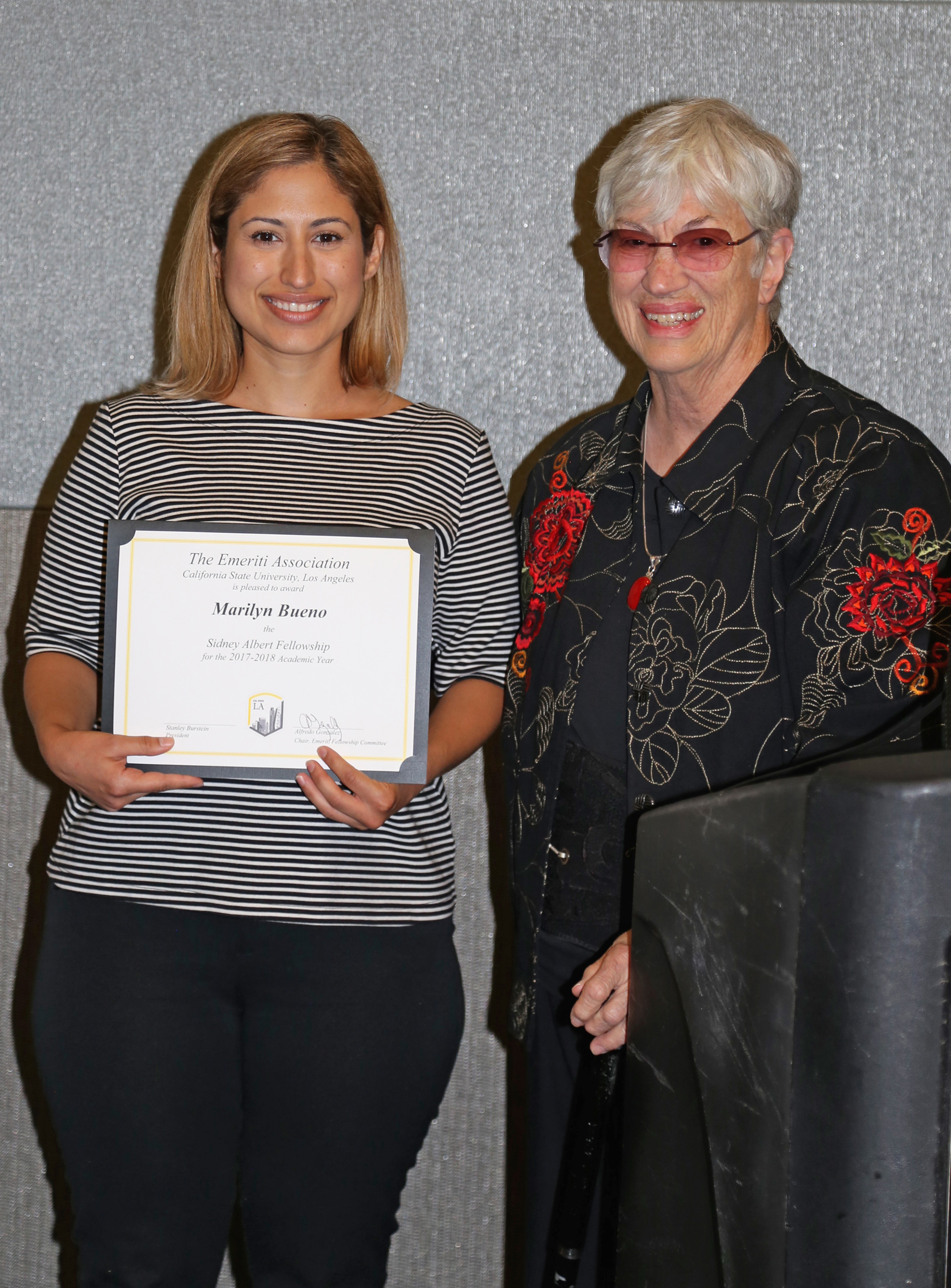 Marilyn Bueno and professor at podium at fall 2017 luncheon