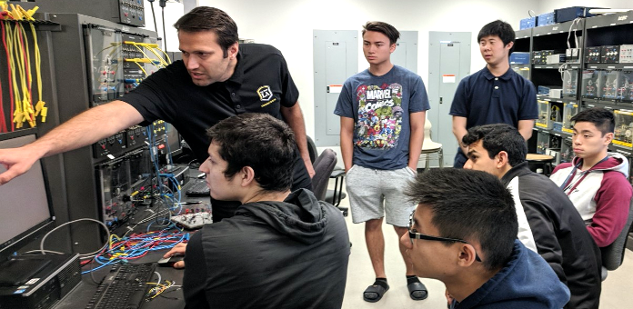 Electrical Engineering faculty works with students in lab