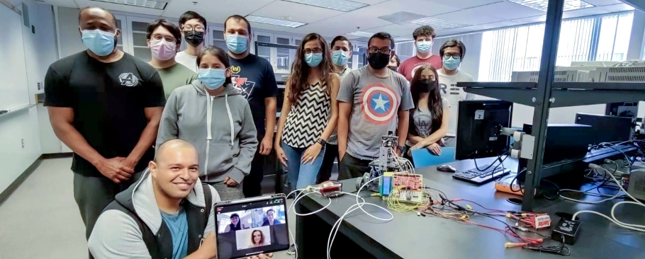 students smile in lab with project