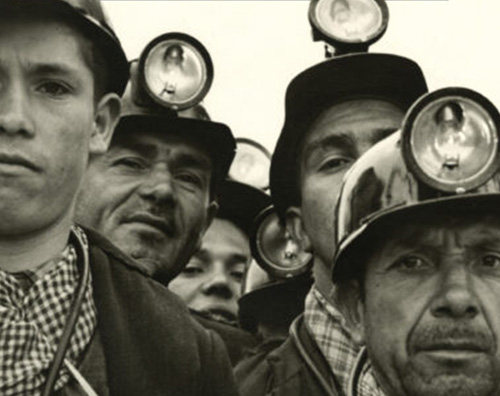 Photo of four men with mining helmets