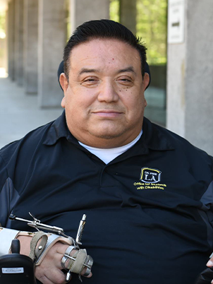 Man smiling to camera in Cal State LA shirt.