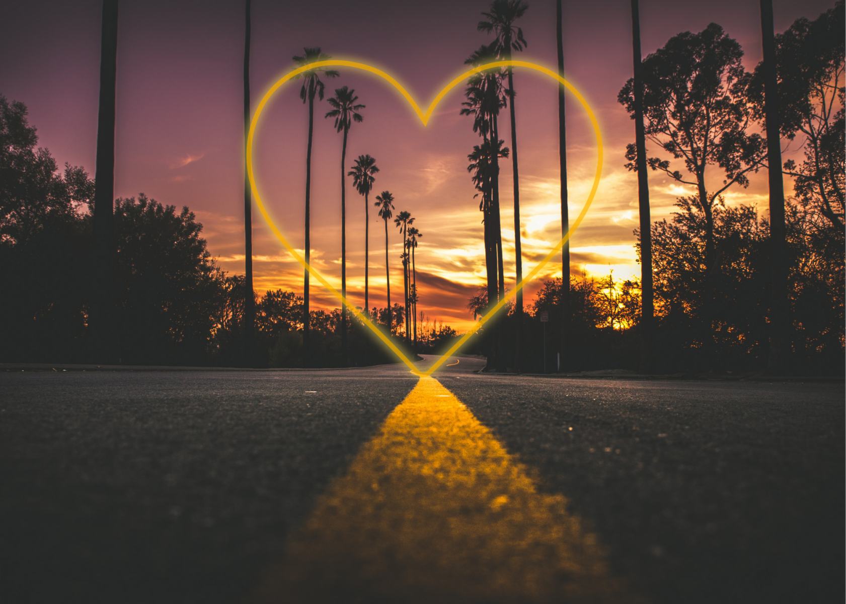 Road that leads to a glowing heart with a sunset in the background. 