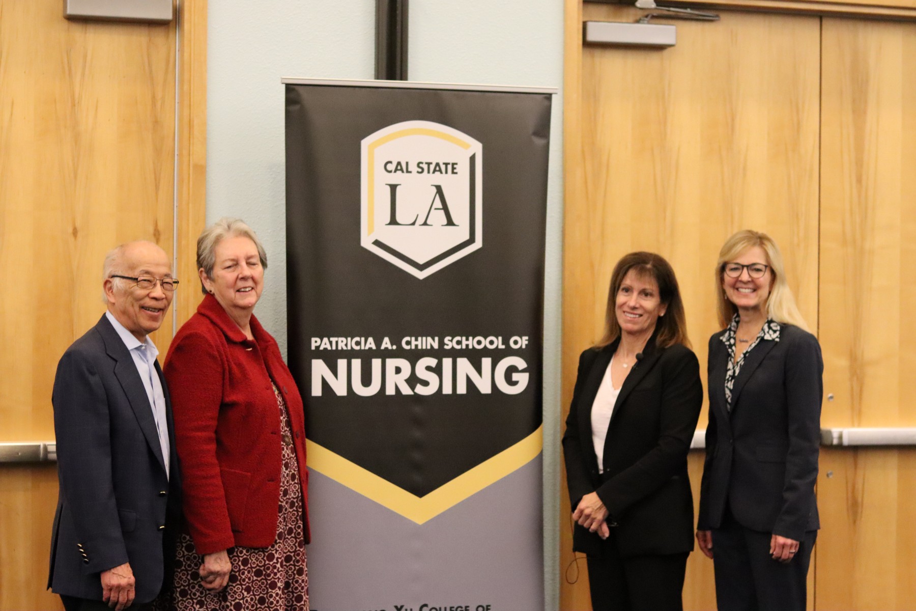 Guest speakers posing in front of nursing sign