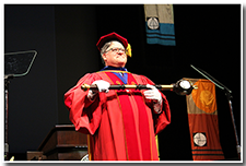 Chair of the Academic Senate and Bearer of the Mace Kevin Baaske holds the mace to lead the procession.