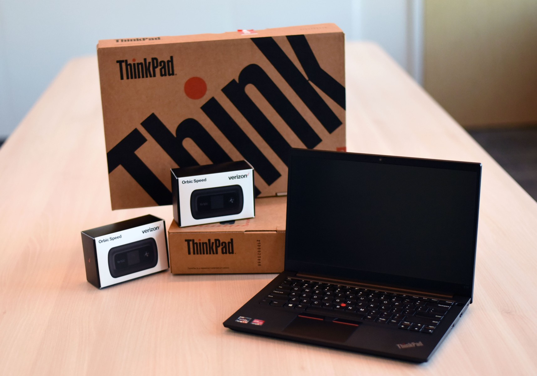 An open laptop, boxes for Think pads and WiFi hotspots arranged on a table.