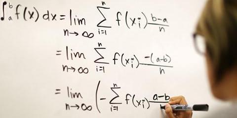 View of a white board with mathematical equations written in black