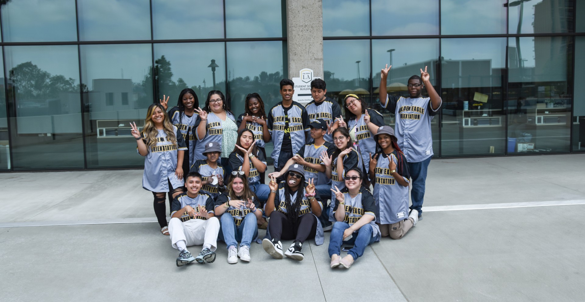 Group of students wearing Orientation jerseys making silly faces and or peace signs with their hands.