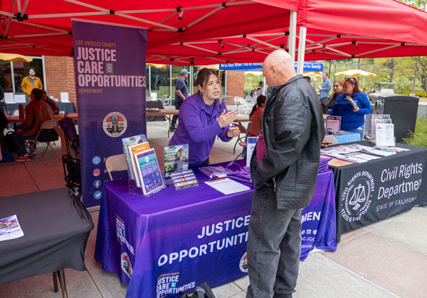 A person hands out information from a kiosk.