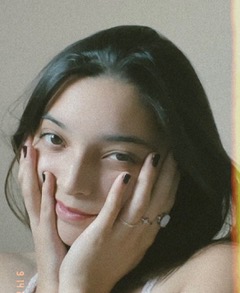 Woman with dark hair wearing white top