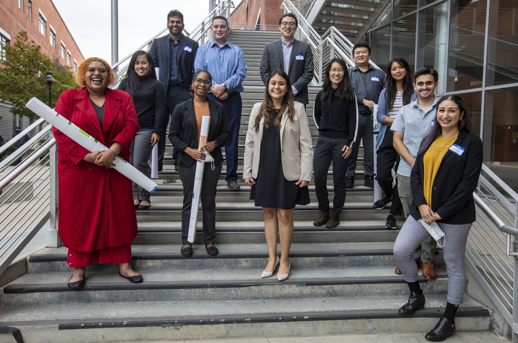 Group of students standing on a staircase smiling. 