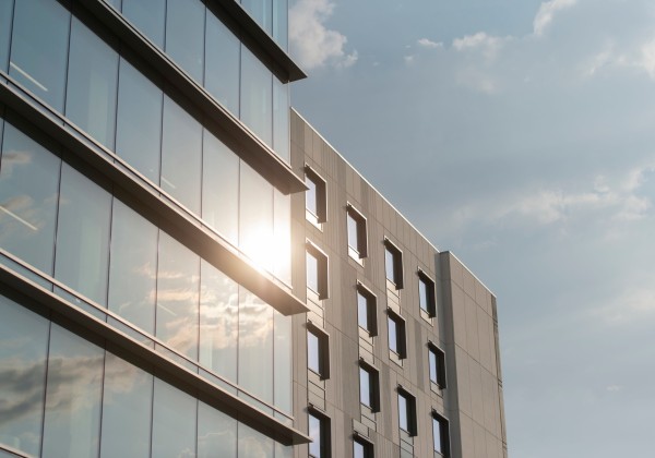 Close up of a building, the sun shining on a the windows.