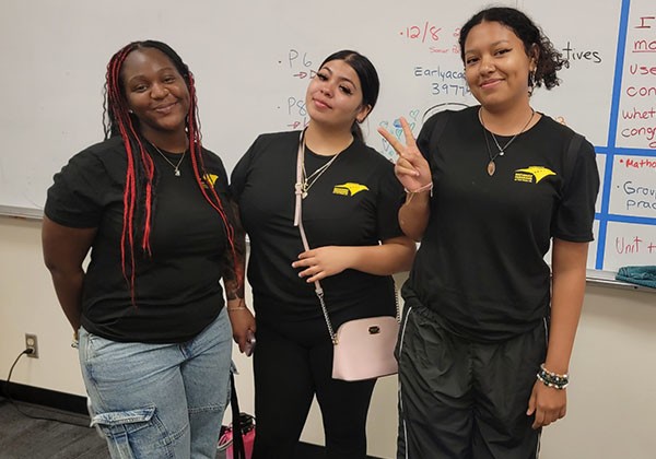 three smiling El Nido program participants in a classroom
