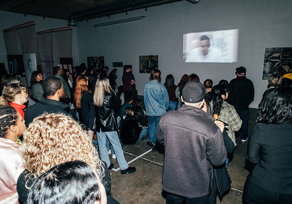 Attendees at art exhibit looking at a visual representation