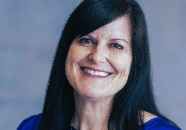 A person with dark hair smiling.