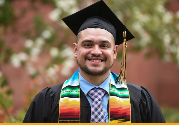 Male graduate wearing black cap and gown.