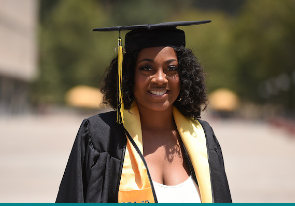 Female graduate in black cap and gown.