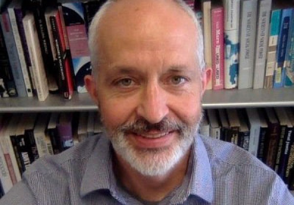 Person with white facial hair smiling