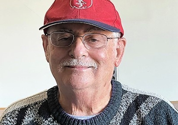 A man wearing a red cap smiling at the camera.